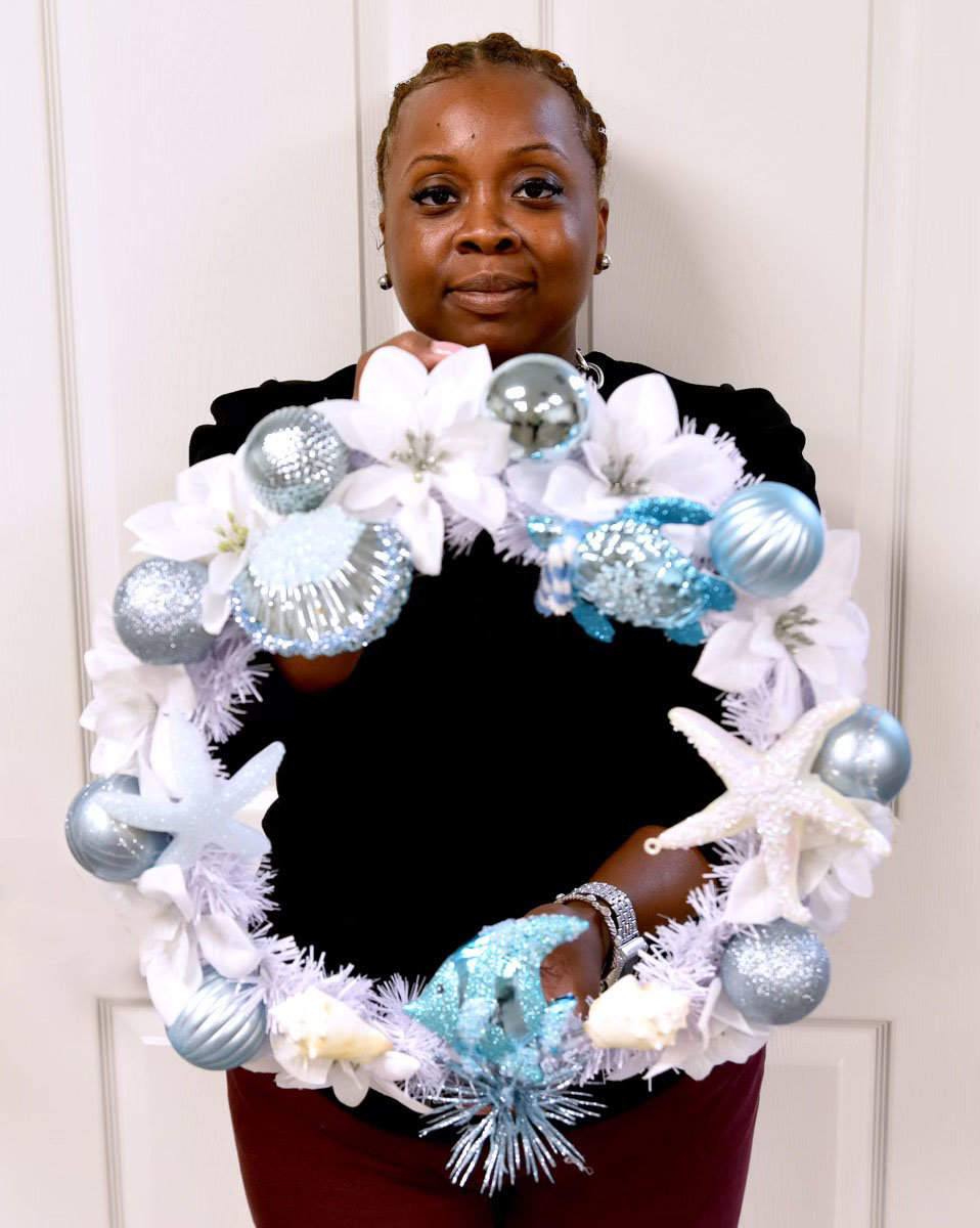 Jazzmine McKenzie displays a nautical holiday wreath available for bid.